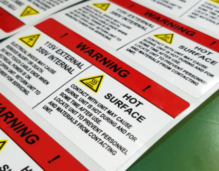 Danger sign banner with warning text,"HOT SURFACE" warning label in electronic industry